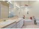 Bright bathroom featuring double sinks, bathtub, neutral colors, and decorative lighting fixtures at 6211 Skyward Ct, Bradenton, FL 34203
