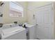 Functional laundry room featuring a washer, dryer, and natural light at 6211 Skyward Ct, Bradenton, FL 34203