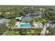 Aerial shot showcasing a community pool area with a large pool, lounge chairs, lush greenery, and palm trees at 6211 Skyward Ct, Bradenton, FL 34203