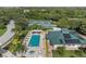 Overhead view of a community pool, surrounded by lounge chairs, manicured lawns, and tennis courts at 6211 Skyward Ct, Bradenton, FL 34203
