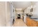 Compact kitchen featuring white cabinetry, essential appliances, and a convenient washer/dryer combo at 6314 29Th W Ave, Bradenton, FL 34209