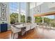Bright dining area with large windows, wooden table, and access to balcony at 6330 Laguna Dr, Longboat Key, FL 34228