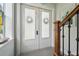 Front entry with double doors, hardwood staircase, and decorative accents at 6330 Laguna Dr, Longboat Key, FL 34228