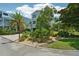 Two-story home with landscaped yard, paver driveway, and palm trees at 6330 Laguna Dr, Longboat Key, FL 34228