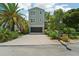 Two-story home with gray siding, paver driveway, and lush landscaping at 6330 Laguna Dr, Longboat Key, FL 34228