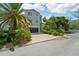 Two-story home with a paved driveway, lush landscaping, and attached garage at 6330 Laguna Dr, Longboat Key, FL 34228