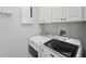 Laundry room with washer, dryer, and cabinets at 6330 Laguna Dr, Longboat Key, FL 34228