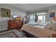 Comfortable bedroom with a dresser, TV, and access to a balcony overlooking the water at 6430 Sun Eagle Ln # 201, Bradenton, FL 34210