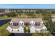 Scenic aerial view of townhomes featuring attached garages, landscaping, and golf course in the background at 6609 Stone River Rd # 206, Bradenton, FL 34203