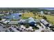 A scenic aerial view features the clubhouse, pool, tennis courts, and parking area near a lake and golf course at 6609 Stone River Rd # 206, Bradenton, FL 34203