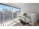 Screened balcony with tile floor, wicker furniture, and a view of the building rooftops and trees at 6609 Stone River Rd # 206, Bradenton, FL 34203