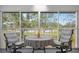 Enclosed balcony with table and chairs overlooking landscaped grounds and the golf course at 6609 Stone River Rd # 206, Bradenton, FL 34203
