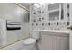 Bathroom with leaf wallpaper, white vanity, bathtub, and sliding glass shower door at 6609 Stone River Rd # 206, Bradenton, FL 34203