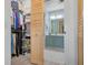 Well-organized walk-in closet leading to a bathroom featuring an elegant vanity and ample lighting at 6609 Stone River Rd # 206, Bradenton, FL 34203
