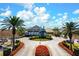 A grand clubhouse entrance with manicured landscaping and circular driveway creating a welcoming and luxurious arrival experience at 6609 Stone River Rd # 206, Bradenton, FL 34203
