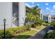 Exterior view of a townhome featuring well-manicured landscaping, a stairway, and a light post at 6609 Stone River Rd # 206, Bradenton, FL 34203