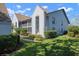 Exterior view of a two-story townhome showcasing lush landscaping, a screened balcony, and neutral paint at 6609 Stone River Rd # 206, Bradenton, FL 34203