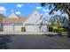 View of three garages with grey doors and black asphalt driveway at 6609 Stone River Rd # 206, Bradenton, FL 34203
