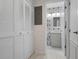 Bright hallway leading to a bathroom featuring white cabinets and leaf-patterned wallpaper at 6609 Stone River Rd # 206, Bradenton, FL 34203