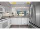White and stainless kitchen featuring stone countertops and appliances with open access to living area at 6609 Stone River Rd # 206, Bradenton, FL 34203