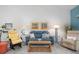 Comfortable living room featuring a blue leather sofa and coastal-themed decor and a neutral palette at 6609 Stone River Rd # 206, Bradenton, FL 34203
