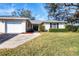 Inviting home exterior with a well-maintained lawn, driveway, and lush landscaping at 7422 W Country Club N Dr, Sarasota, FL 34243