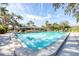Community pool with clear water and palm trees, surrounded by lounge chairs and inviting seating areas at 7422 W Country Club N Dr, Sarasota, FL 34243
