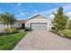 Attractive single story home with gray garage door and stone accents; features a neatly landscaped front yard at 8669 Rain Song Rd, Sarasota, FL 34238