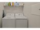 Bright laundry room with washer, dryer, and shelving at 8669 Rain Song Rd, Sarasota, FL 34238