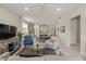 Open concept living room with a view of the kitchen and dining area; features comfortable seating and a large TV at 8669 Rain Song Rd, Sarasota, FL 34238
