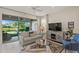 Living room features a comfy sofa, glass-top coffee table, and sliding glass doors that open to the outdoors at 8669 Rain Song Rd, Sarasota, FL 34238