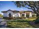 Single-story home with tile roof, manicured landscaping, and a long driveway at 1060 Water Oak Ne Ct, St Petersburg, FL 33703