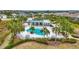 Aerial view of a sparkling community pool surrounded by palm trees and lounge chairs at 11630 Woodleaf Dr, Bradenton, FL 34211