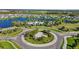 Aerial view of a lakefront community with a roundabout entrance and amenities nearby at 11794 Little River Way, Parrish, FL 34219