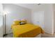 Bright bedroom with a yellow bedspread, featuring a double door closet, a window, and carpet flooring at 11794 Little River Way, Parrish, FL 34219