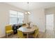 Cozy dining area featuring a wood table, stylish yellow chairs, and natural light from a large window at 11794 Little River Way, Parrish, FL 34219