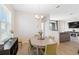 Bright dining room features hardwood floors and a modern chandelier with seating for four at 11794 Little River Way, Parrish, FL 34219