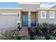 A welcoming front entrance with a blue door, stone accents, and beautiful landscaping at 11794 Little River Way, Parrish, FL 34219