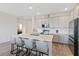 Modern kitchen featuring an island with bar seating, white cabinetry, and stainless steel appliances at 11794 Little River Way, Parrish, FL 34219