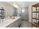 Main bathroom showcases double vanity, walk-in shower, gray cabinets and tile floors at 11794 Little River Way, Parrish, FL 34219