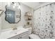 Updated bathroom features a white vanity, stylish mirror, and a floral shower curtain at 120 Tidy Island Blvd # 120, Bradenton, FL 34210