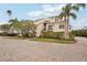 Tan condo building with paved driveway and lush landscaping at 120 Tidy Island Blvd # 120, Bradenton, FL 34210