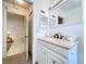 The bathroom features an updated vanity, large mirror, and is located next to a doorway leading to another room at 1210 56Th W St # 1210, Bradenton, FL 34209