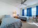 Bright bedroom with two twin beds, blue accents, ceiling fan, carpet floors, and lots of natural light at 1210 56Th W St # 1210, Bradenton, FL 34209