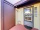 Close-up of the front door with decorative glass and a small stool at 1210 56Th W St # 1210, Bradenton, FL 34209