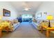 Bright living room featuring floral sofas, carpeted floor, and natural light, creating a welcoming atmosphere at 1210 56Th W St # 1210, Bradenton, FL 34209