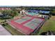 Aerial view of two well-maintained tennis courts next to the pool and community center at 1210 56Th W St # 1210, Bradenton, FL 34209