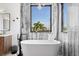 Free-standing bathtub with large window overlooking palm trees at 130 Burns Rd, Terra Ceia, FL 34250