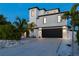 Contemporary three-story home with a dark garage door at 130 Burns Rd, Terra Ceia, FL 34250