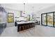 Modern kitchen with dark cabinetry, marble backsplash, island with seating, and breakfast bar at 130 Burns Rd, Terra Ceia, FL 34250